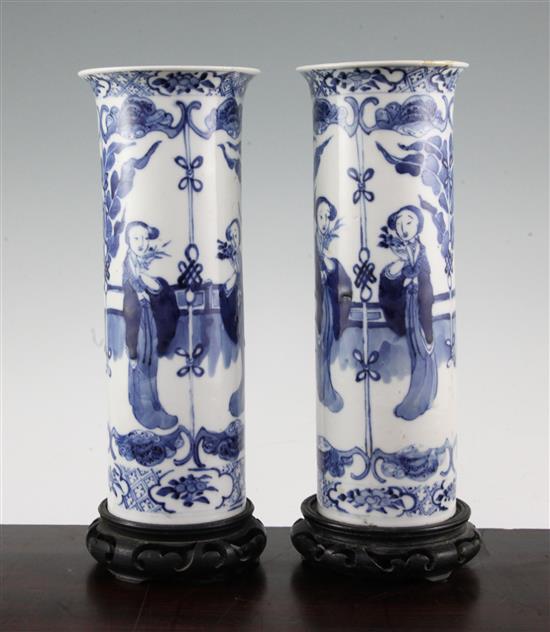 A pair of Chinese blue and white Long Eliza cylindrical vases, late 19th century, 26cm., ebonised wood stands